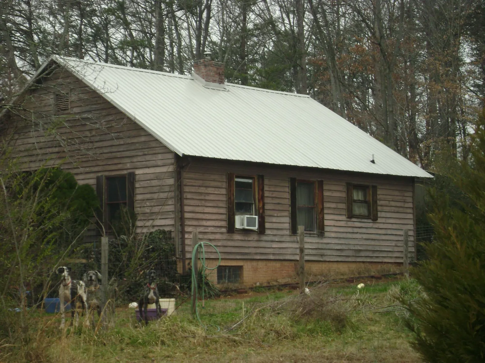 White metal roof on an old wood sided farmhouse, from a Asphalt Shingle Roof Repair job in Prague